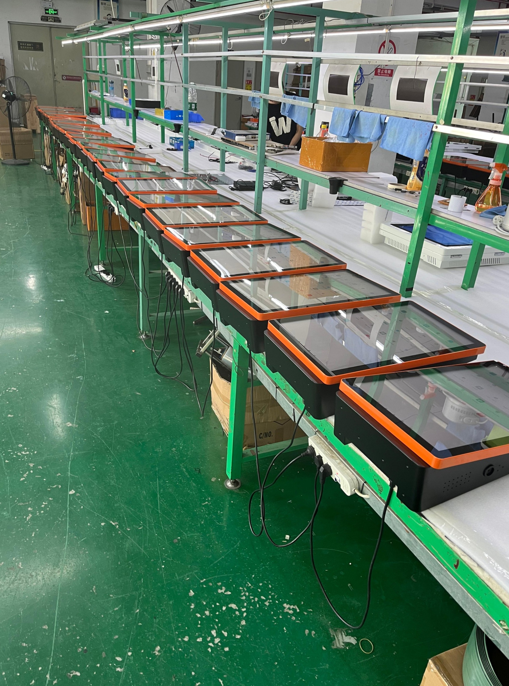 Linea di produzione dei totem: schermi montati in sequenza